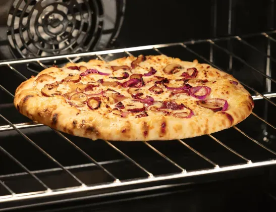 Inside of the GE Profile 30-inch Smart Slide-In Induction Range (PHS700AYFS) showing a cooked pizza.